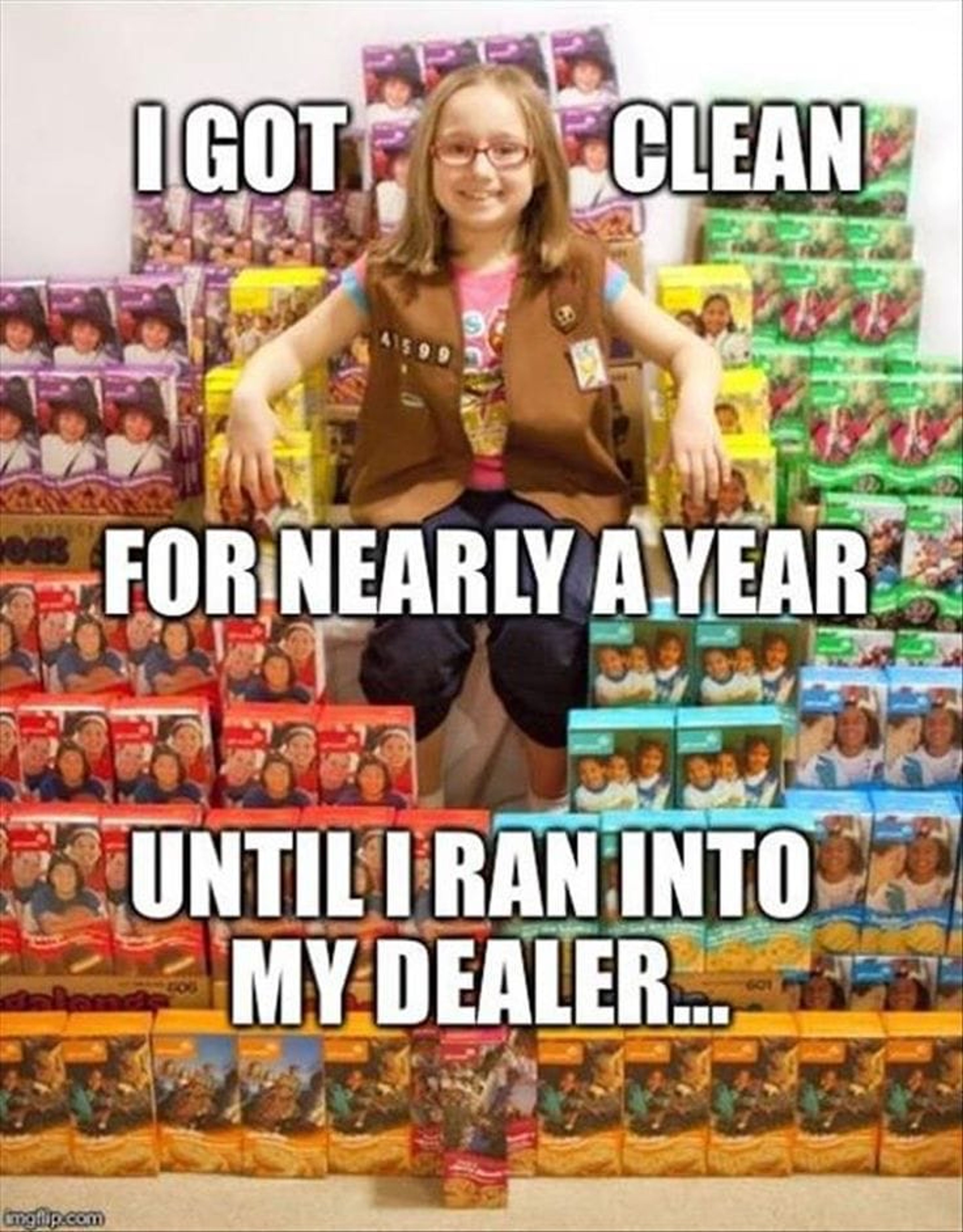 A Girl Scout sitting on a pile of different girl scout cookies