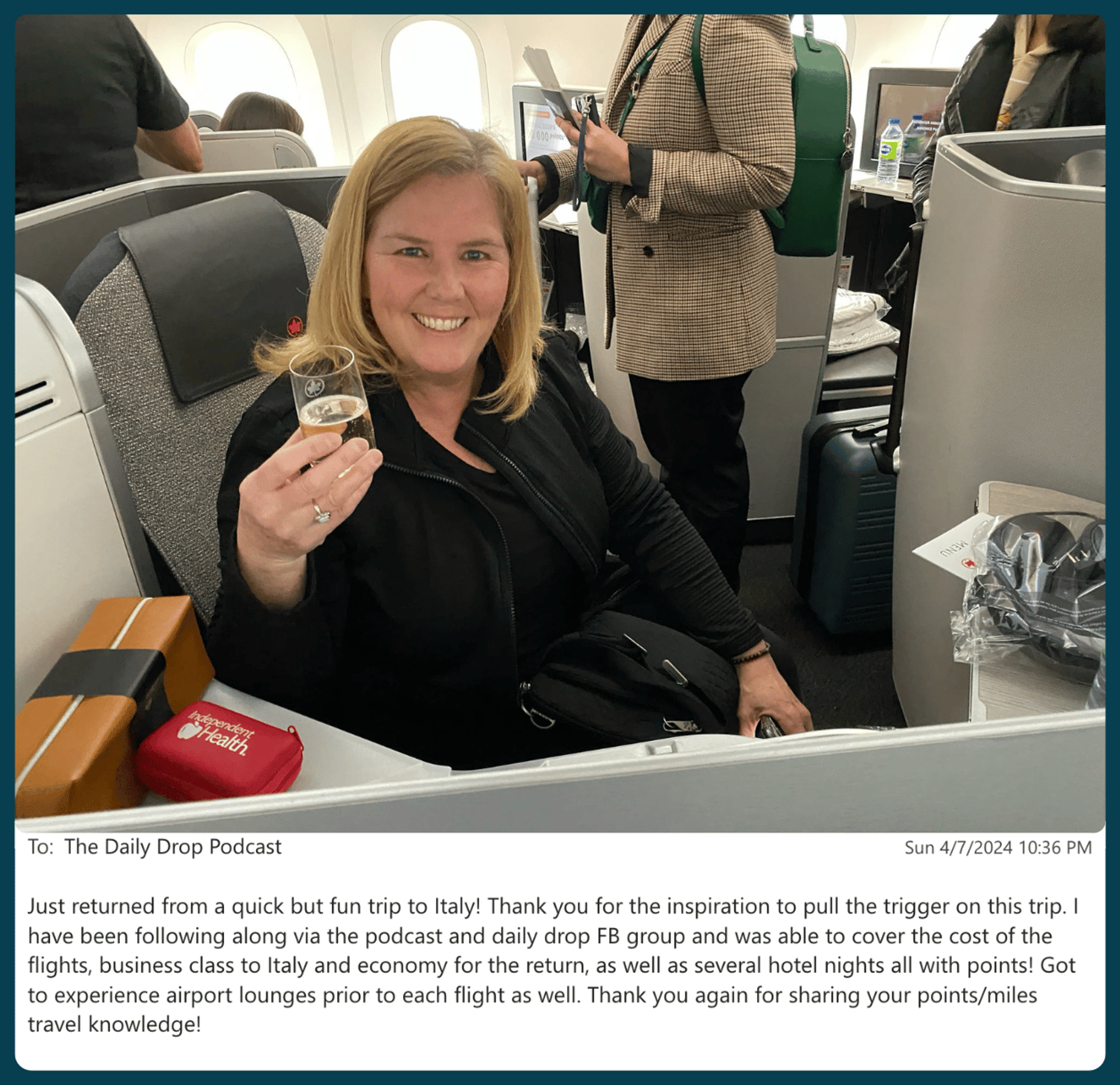 A woman sitting in a business class seat, holding up a glass of champagne