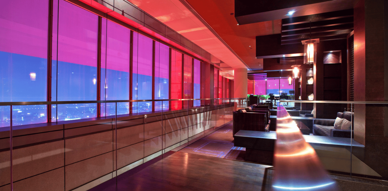 An image of a lounge with dark purple and red colors with seating