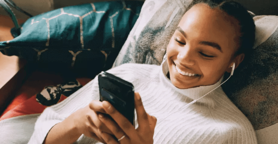 An image of a girl lying down looking at her phone