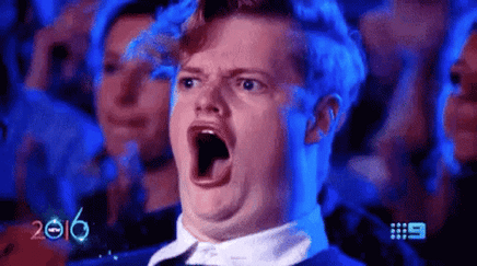 A man with his mouth wid open and applauding