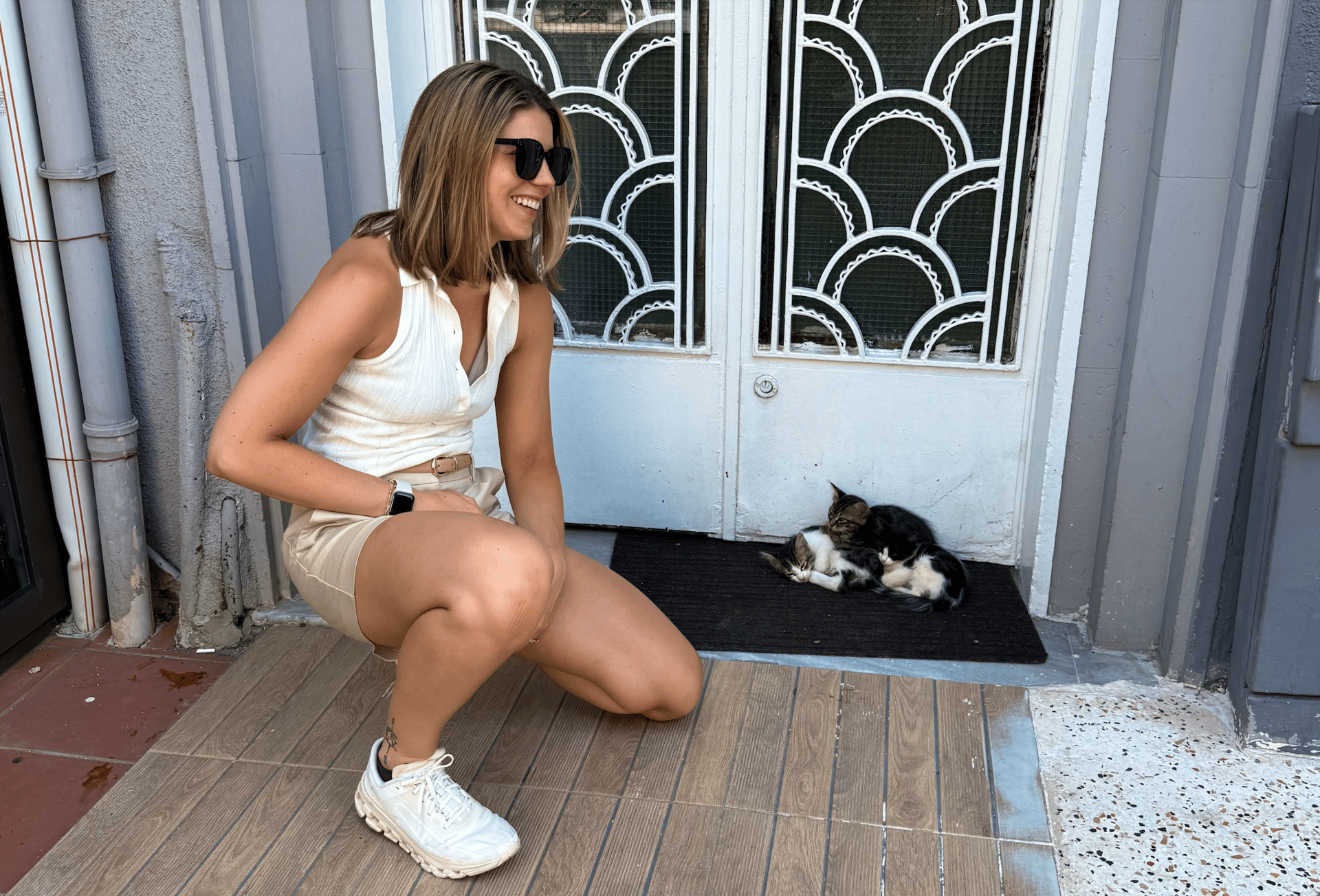 A woman kneeling next to kittens