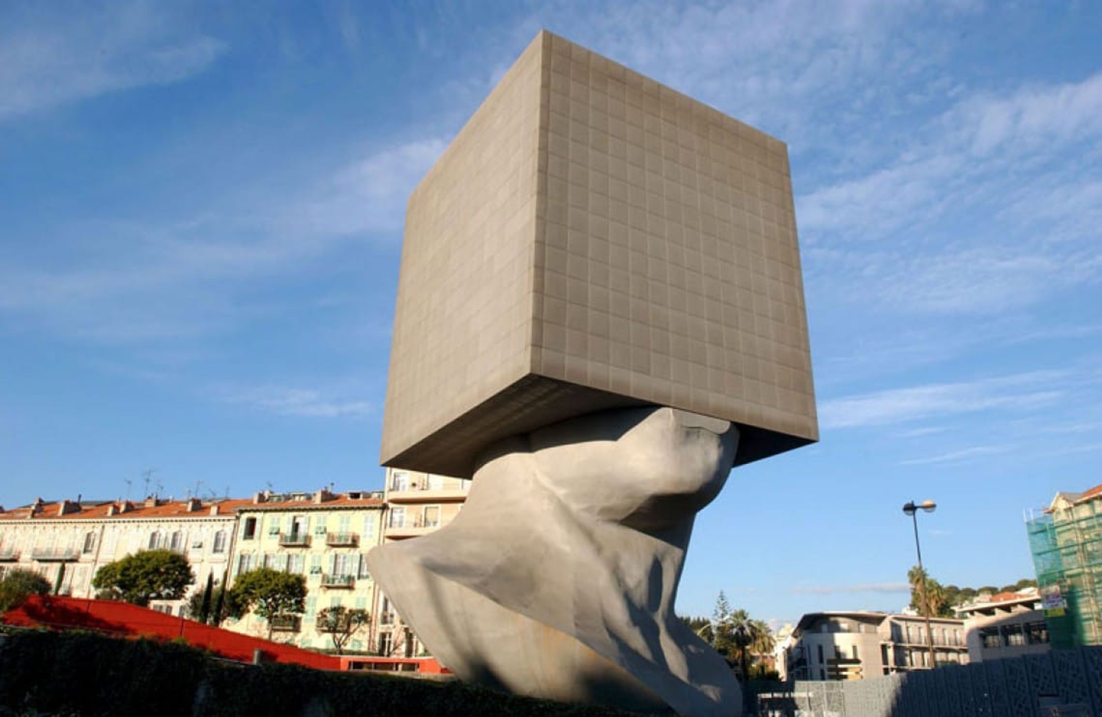 A sculpture of a head with a massive block