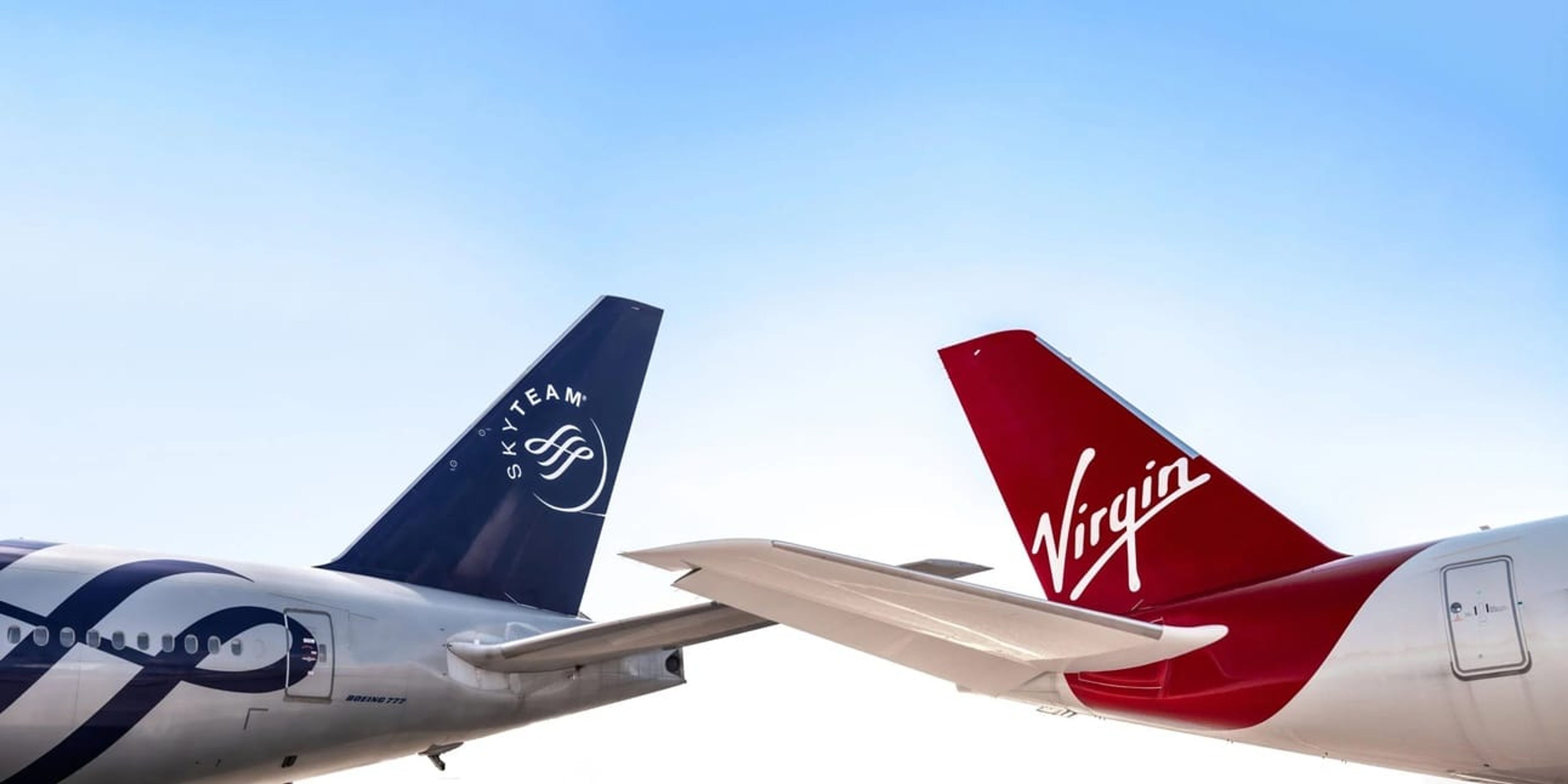 A photo of two planes; one is virgin atlantic and th other has SkyTeam livery