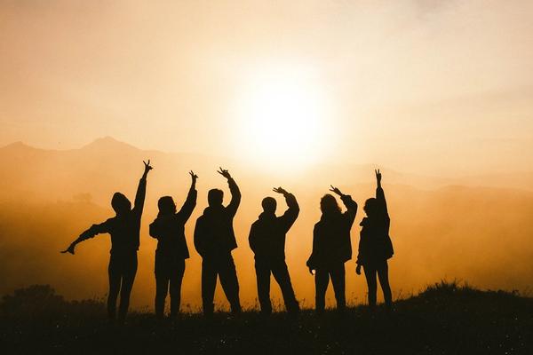 a group of people waving at the sun