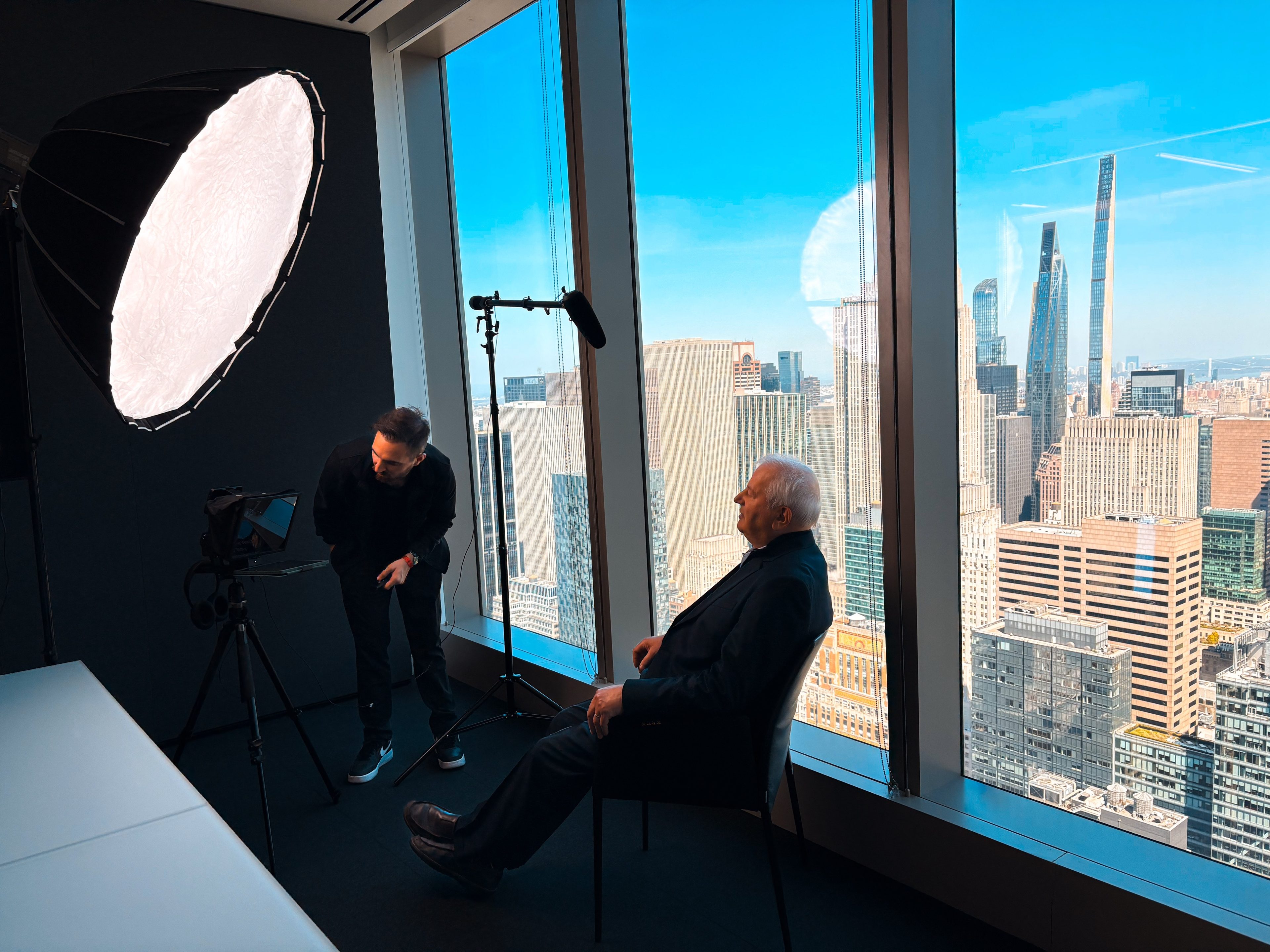 Interview set in a Manhattan high-rise, softbox and camera facing the guest with the skyline behind