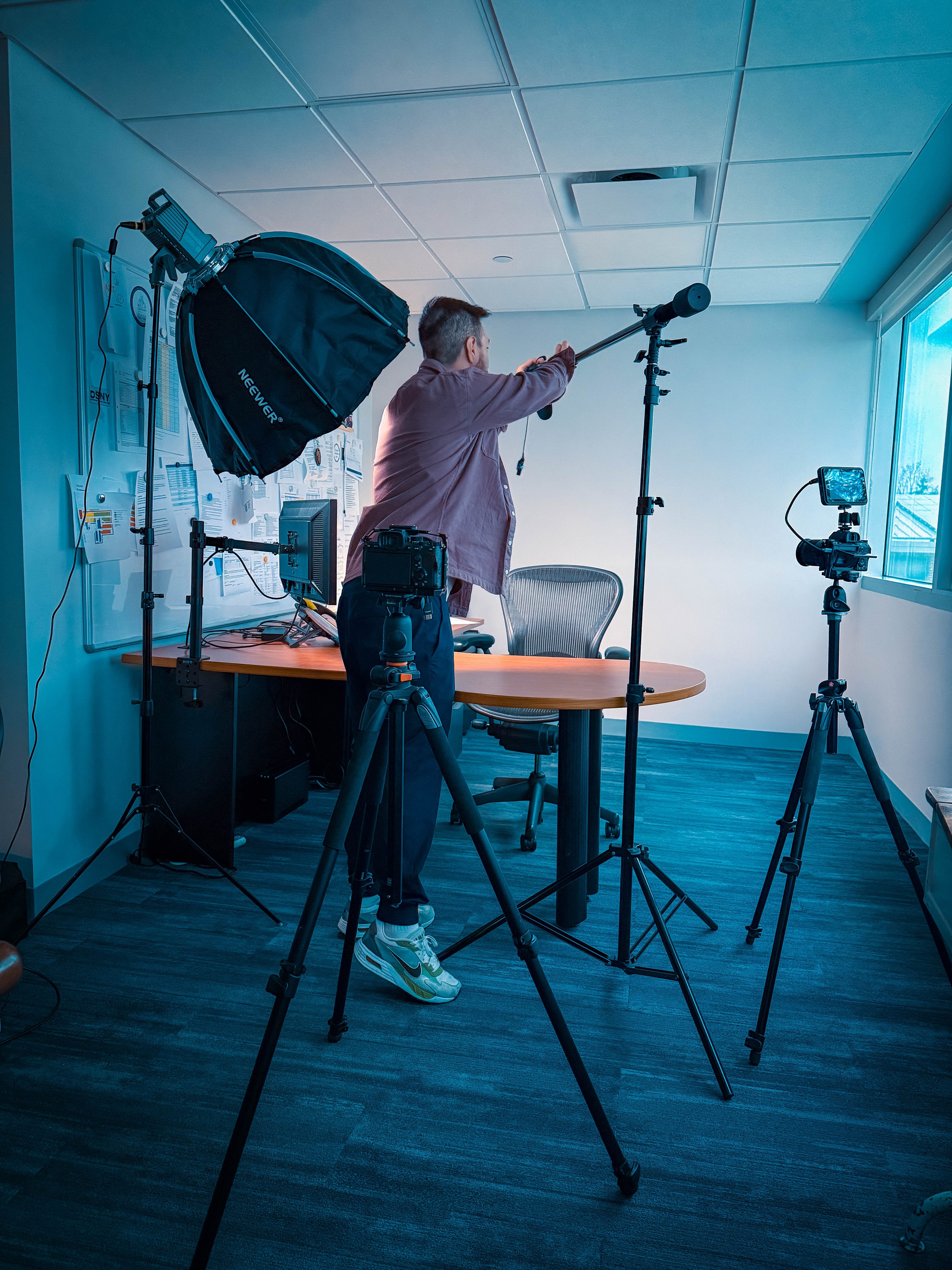 Setting up lights and a boom mic in an office