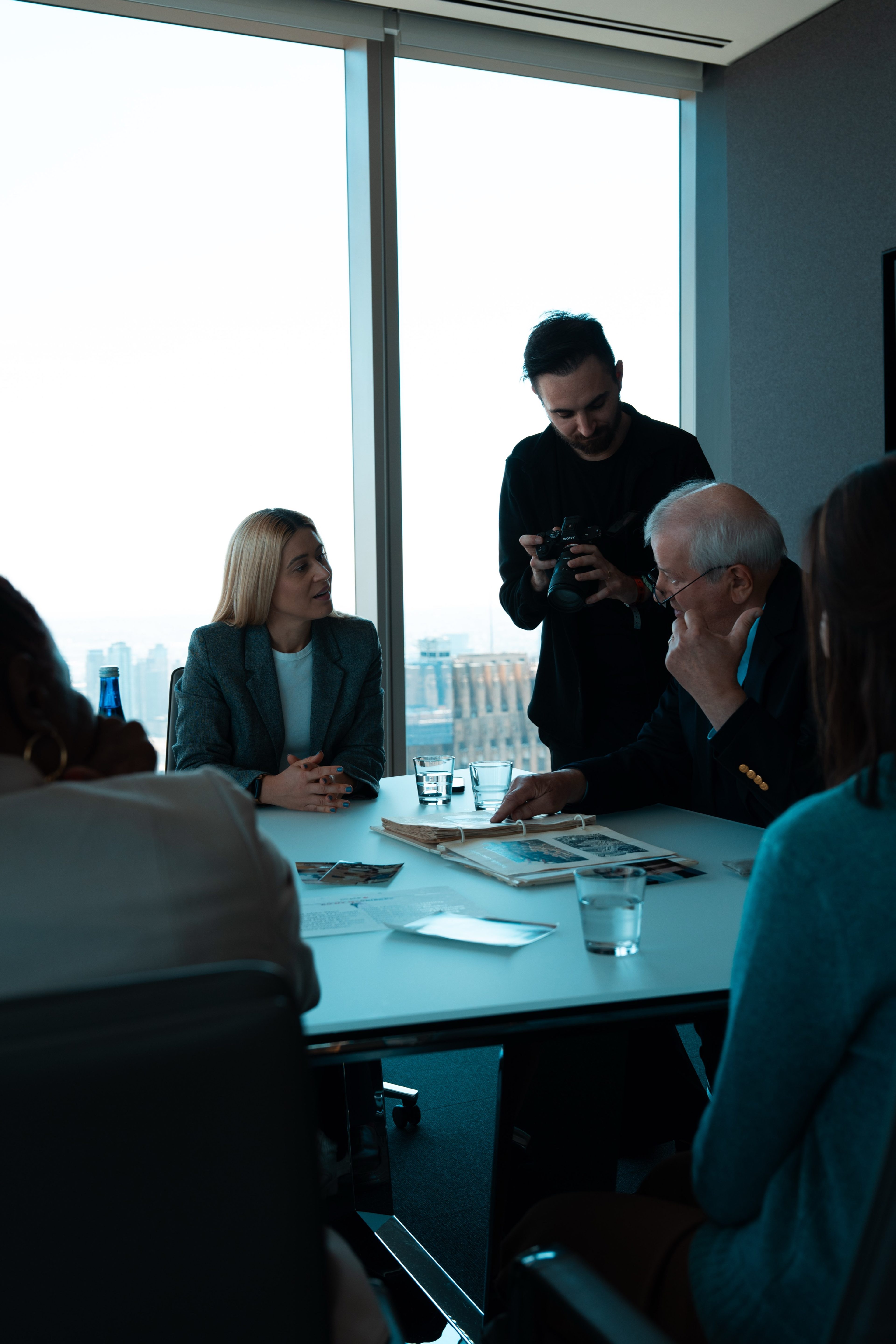 Crew filming a conversation around a conference table