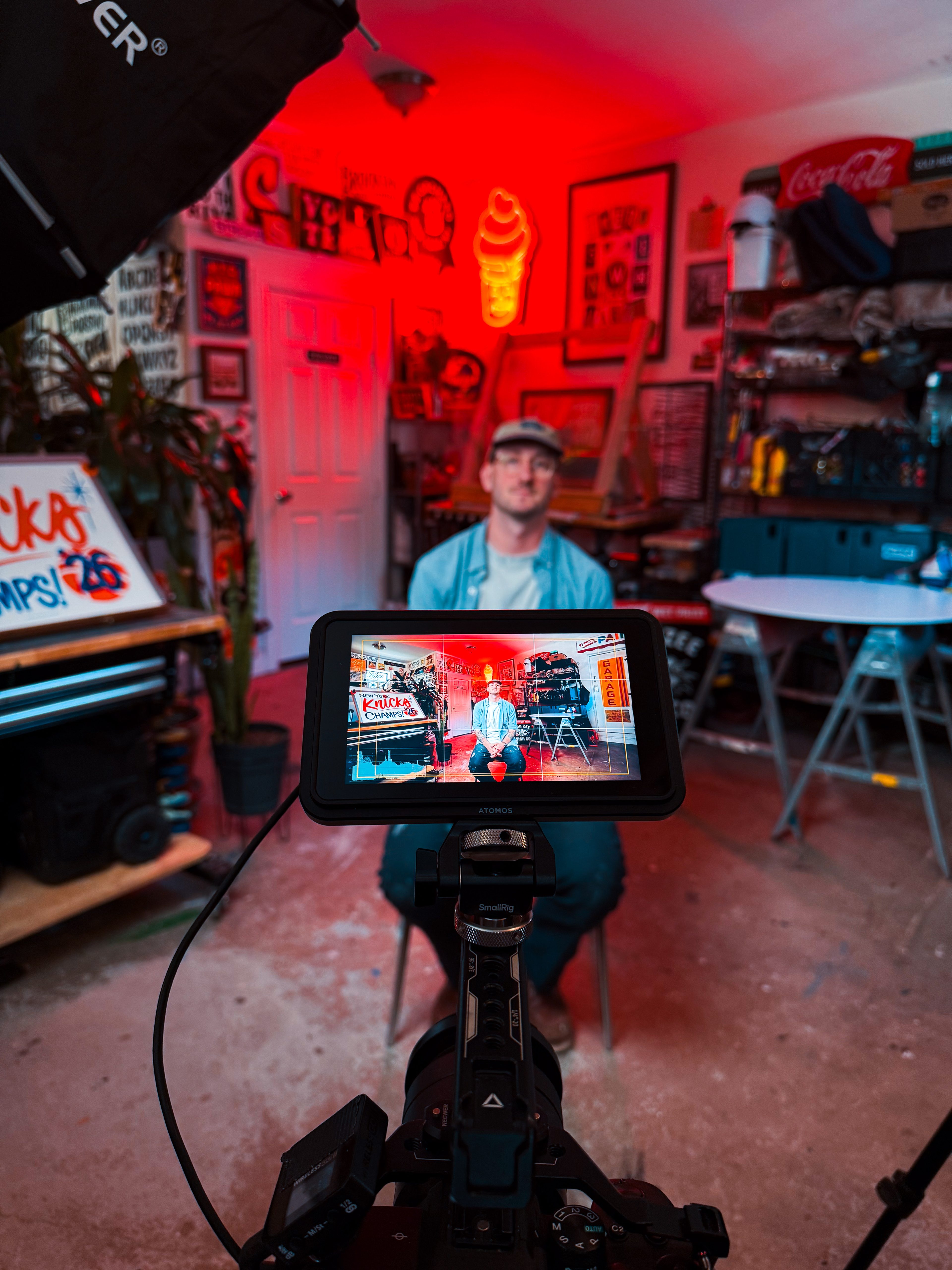 Camera monitor framing the sign artist in his studio