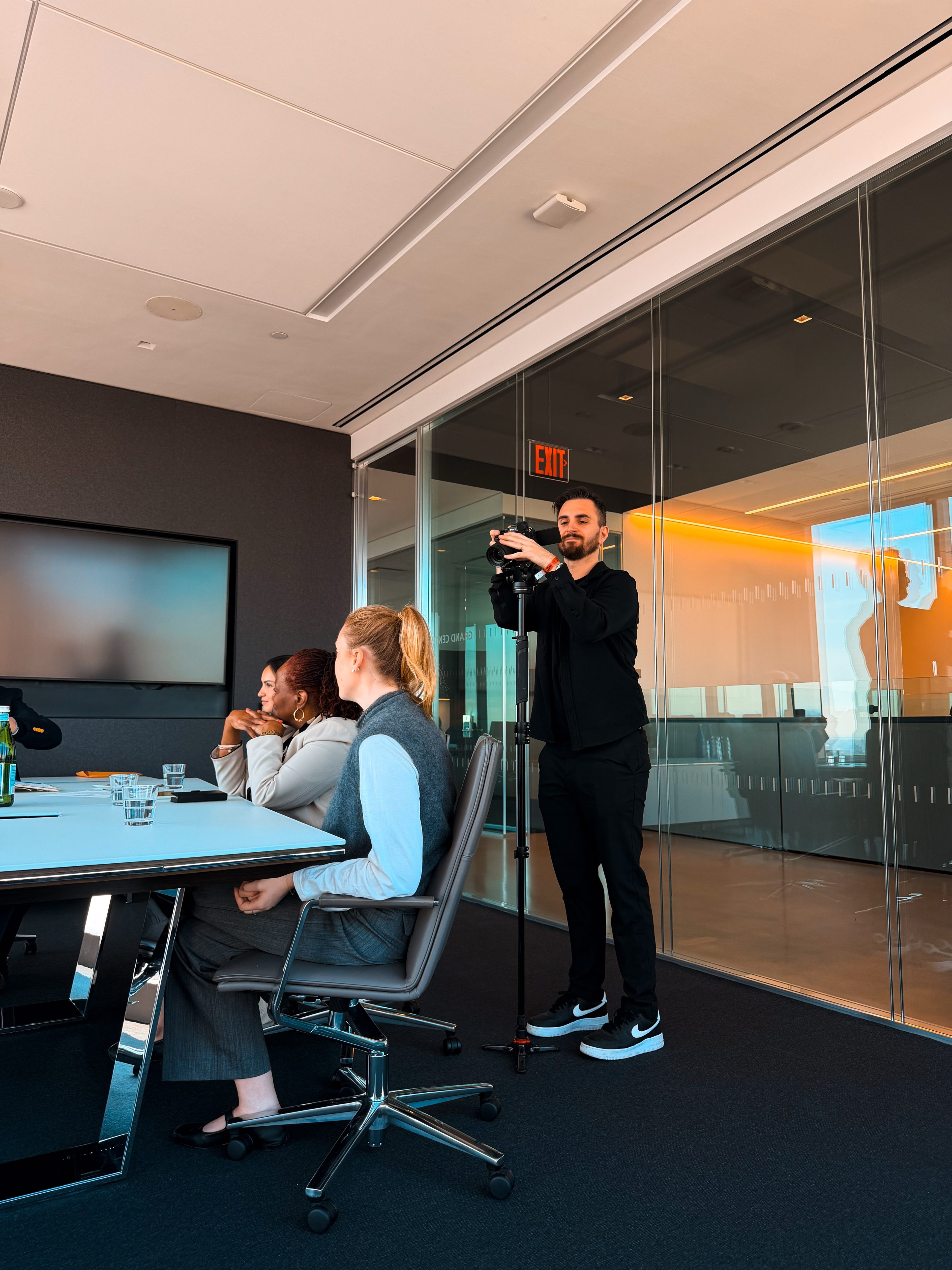 Filming a meeting in a glass-walled conference room