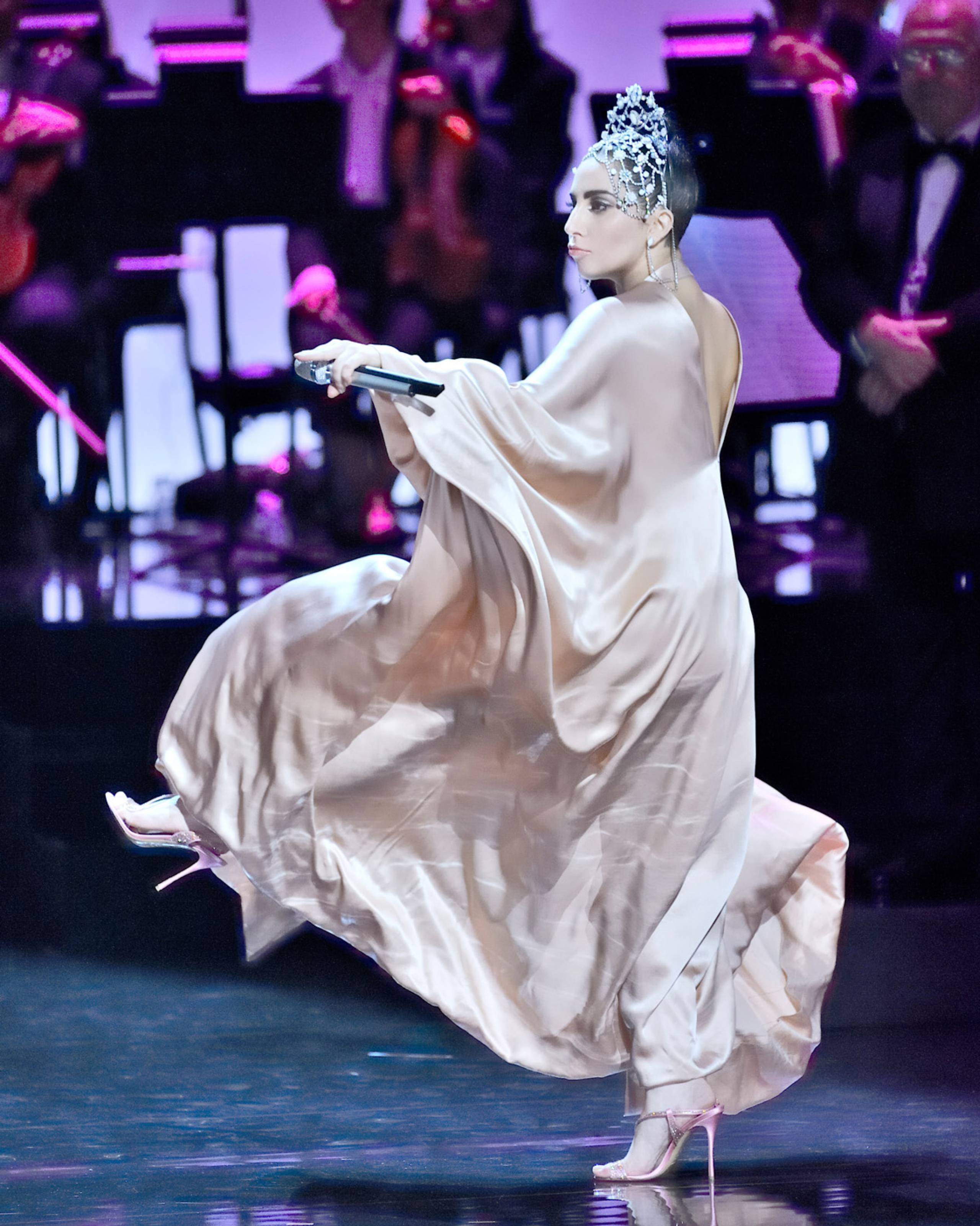 Lady Gaga on stage dancing in a flowy dress