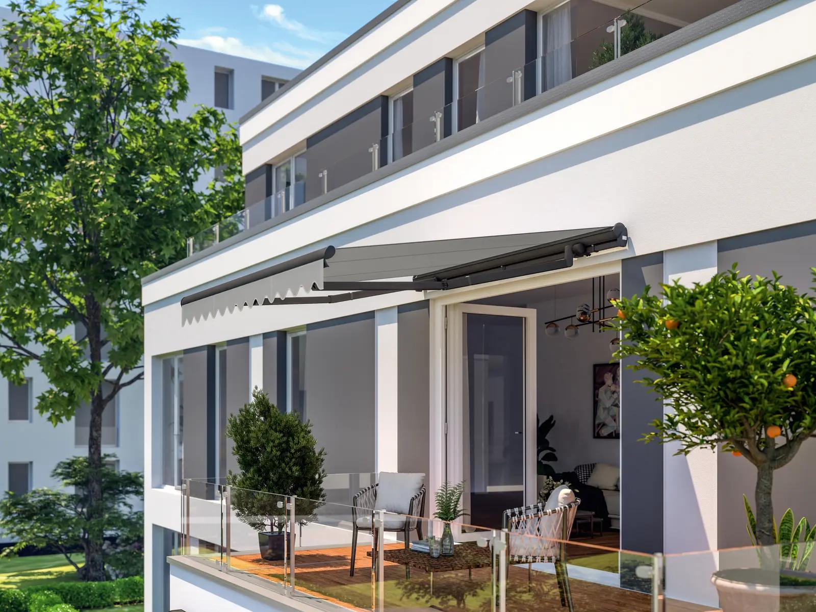 Kassettenmarkise mit grauem Tuch über der Terrasse eines hellen Mehrfamilienhauses