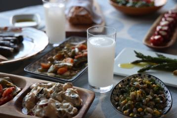 Et bord fylt med meze og glass med ouzo blandet med vann.