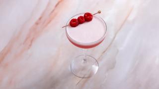 Ferdigblandet rosa cocktail med bringebær.