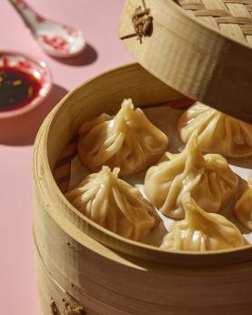 Ferdig dampet dumplings i en bambuskurv.