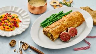 Fat med nøttestek i butterdeig appelsinsalat og soppsaus ved siden av.