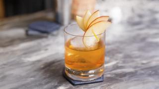 Ferdigblandet cocktail med mezcal og whisky pyntet med eple.