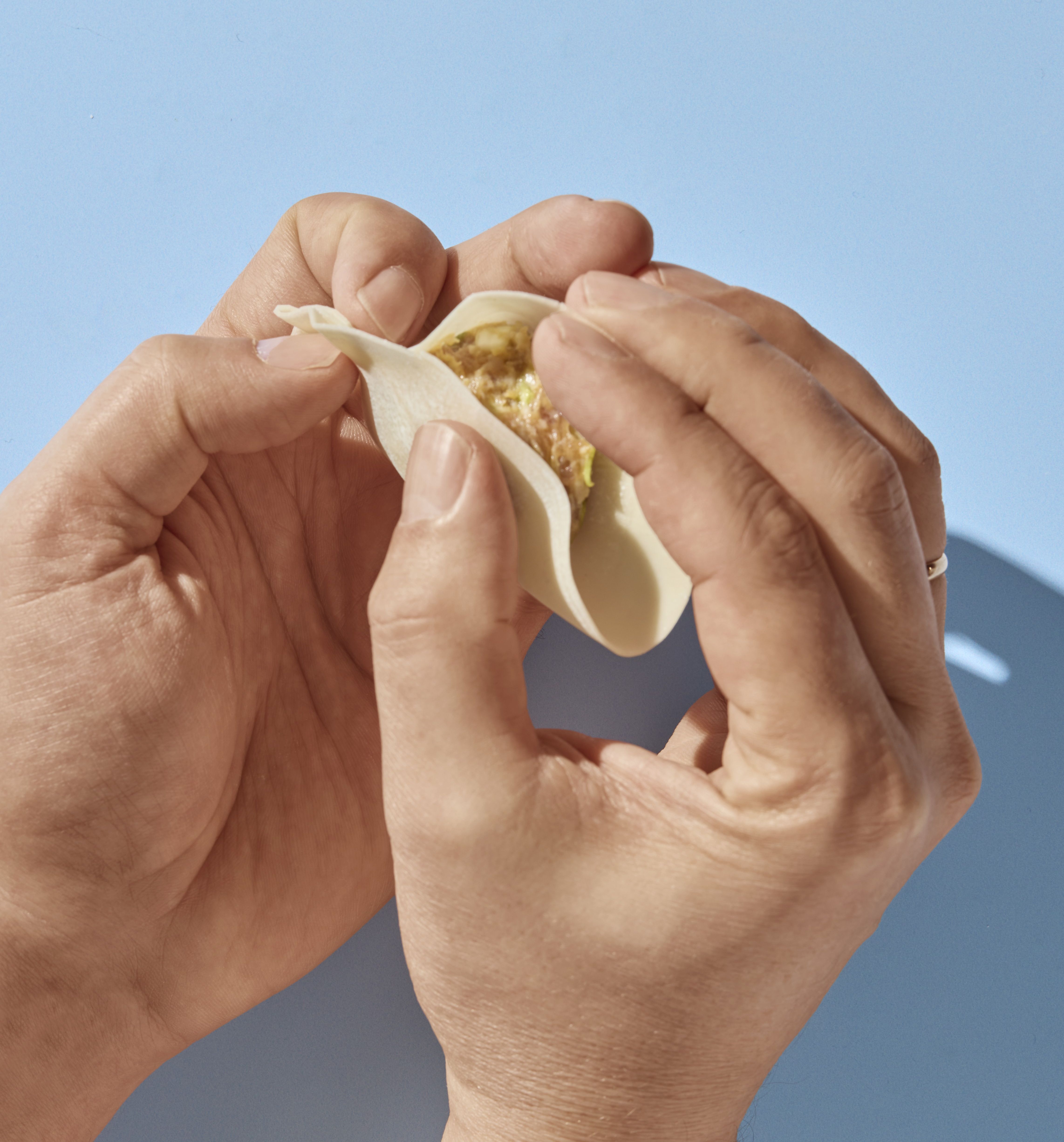 Hender som bretter gyoza.