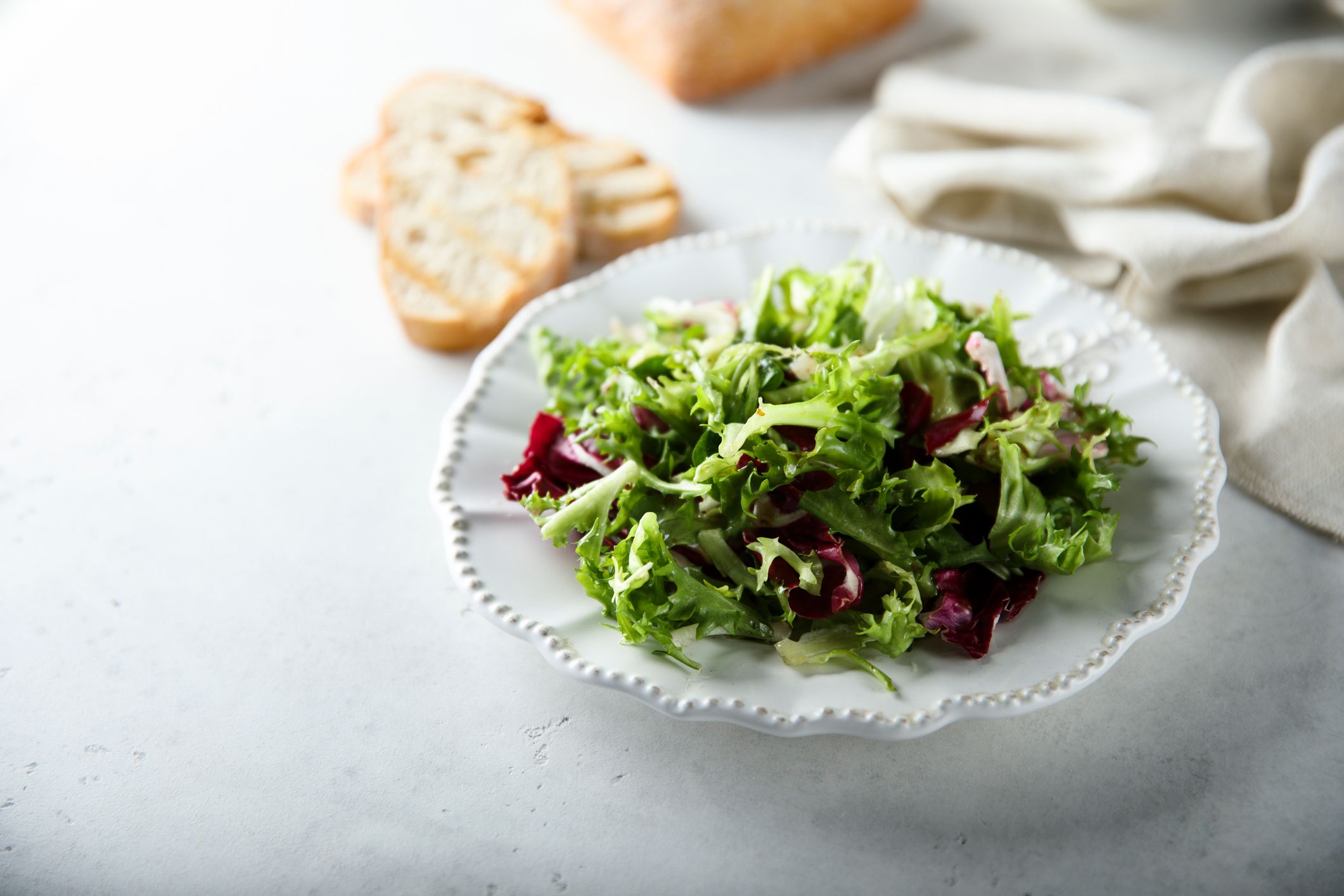 Grønn salat på hvit tallerken.