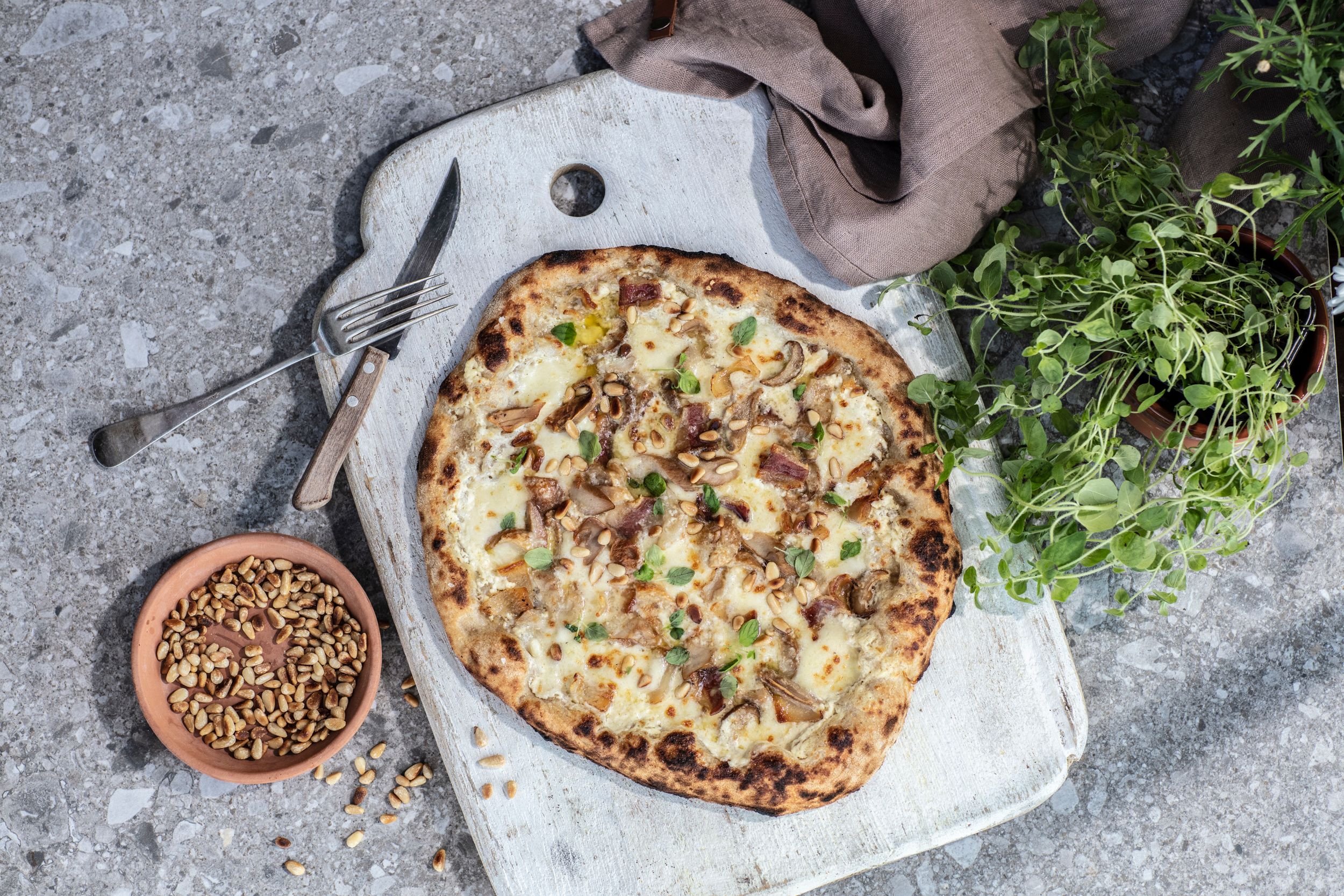 Bord med stekt pizza på en fjøl.