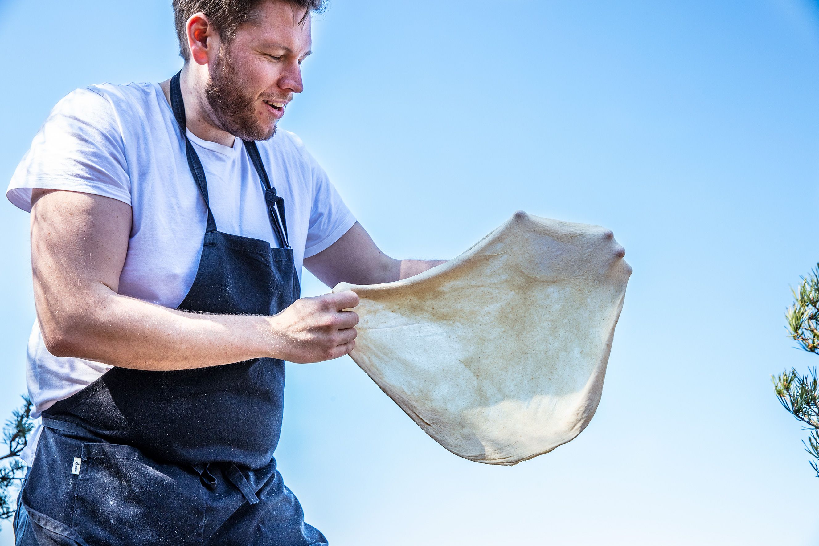 Kokken Andreas Ingul som holder pizzadeig.