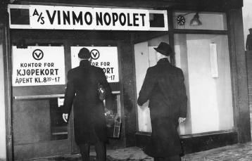 To menn går inn på Vinmonopolet