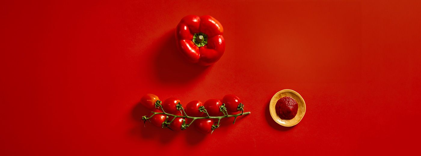 Rød bakgrunn med tomat, paprika og tomatpure.