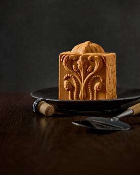 en hel håndverksbrunost, ostehøvel, og en madeirakork.