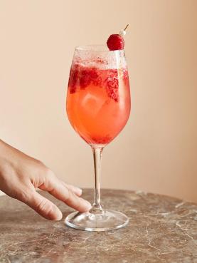Rosespritzer pyntet med bringebær, servert i vinglass
