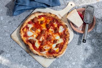 Bord med stekt pizza på en fjøl.