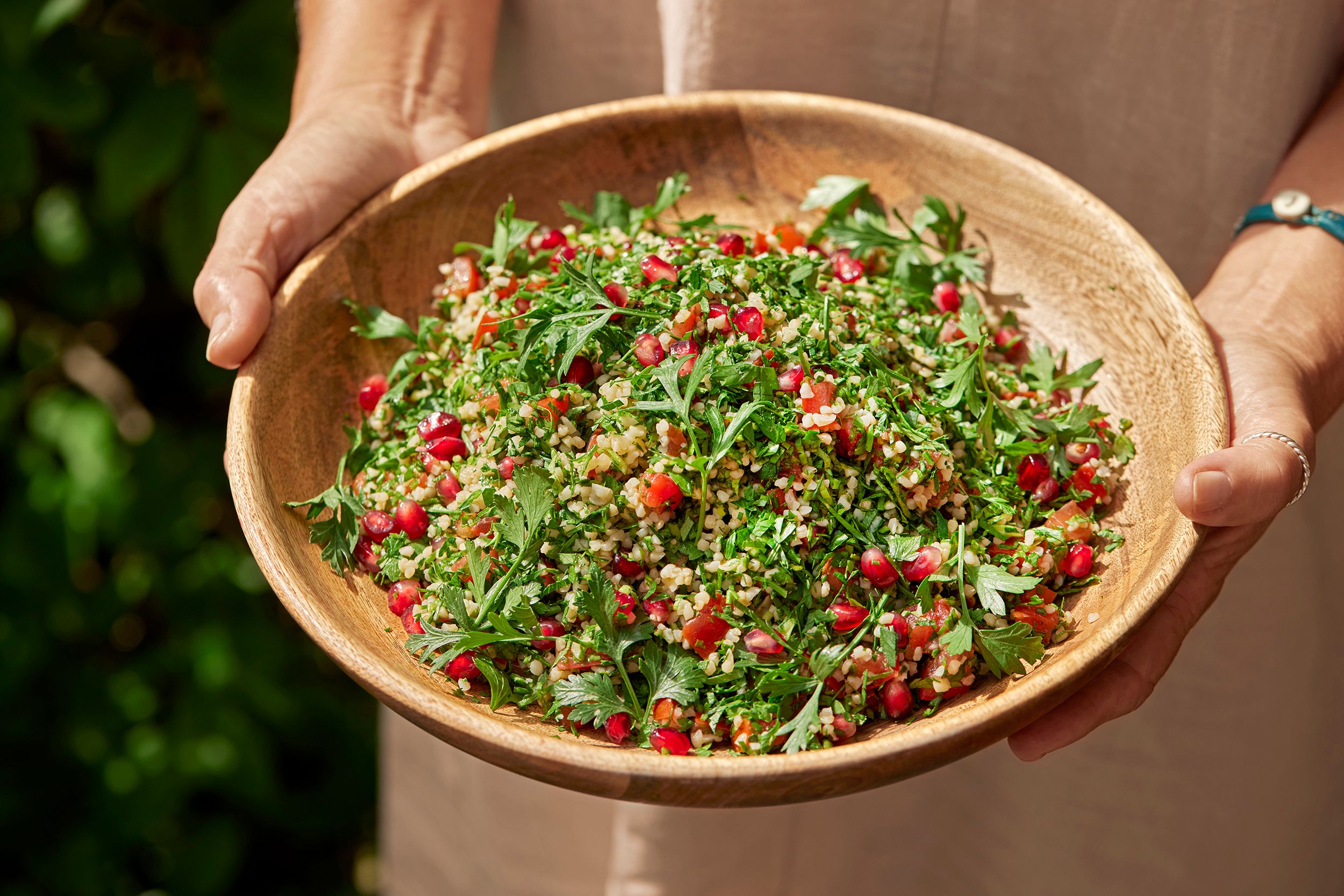 Person som holder en bolle med tabouleh-salat.