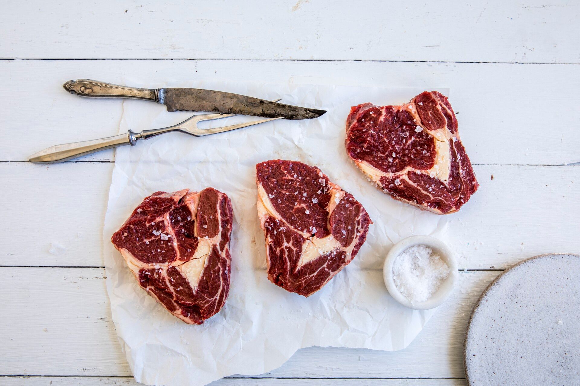 Tre stykker rå entrecote med saltdryss.