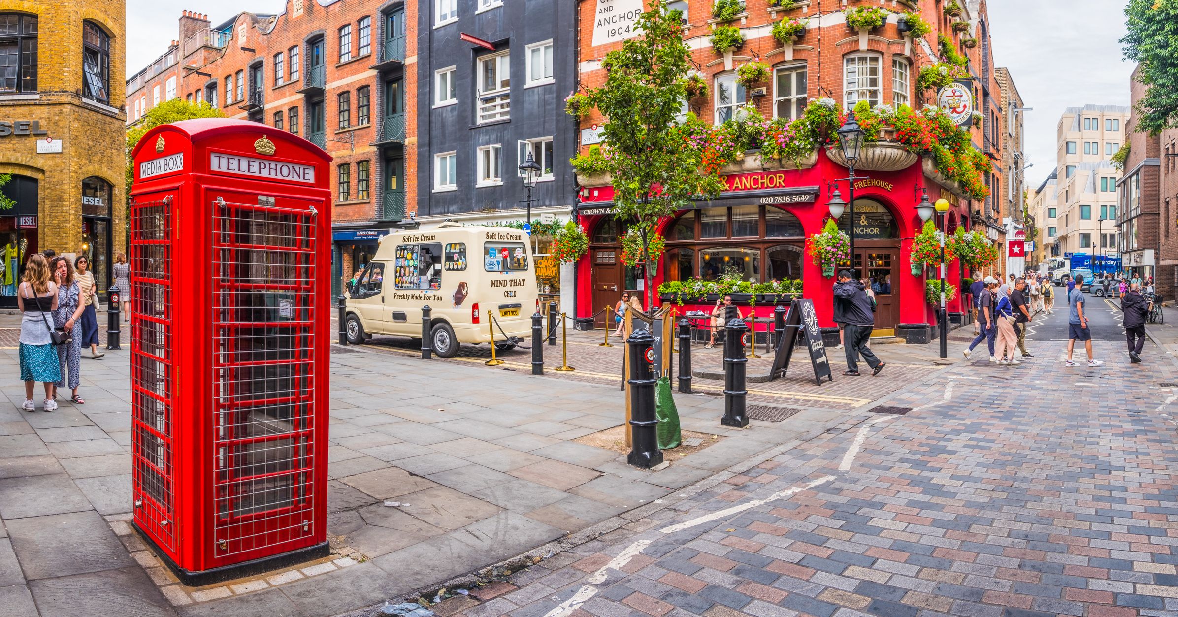 Gate i London med en rød telefonkiosk og pub.