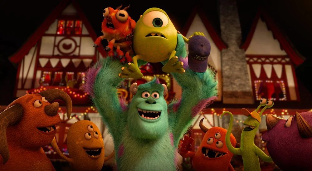 Sulley lifts Mike above his head as other monsters cheer in Monsters University