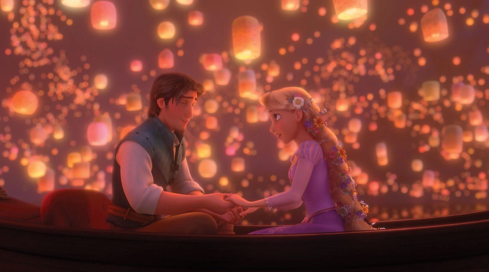 Rapunzel and Flynn hold hands in a boat beneath glowing lanterns in Tangled