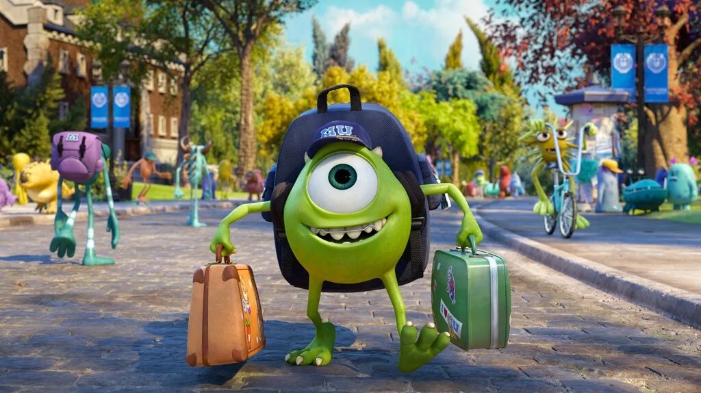 A smiling young Mike stands on a leafy campus path wearing a blue MU cap, holding two suitcases. Other student monsters and autumn trees fill the background.