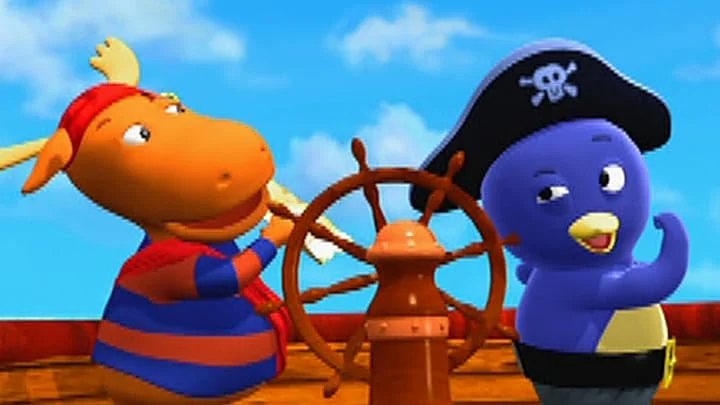 Tyrone in a red bandanna stands at a ship’s wheel. Austin wears a black pirate hat and gestures on the right, with a bright blue sky behind them.