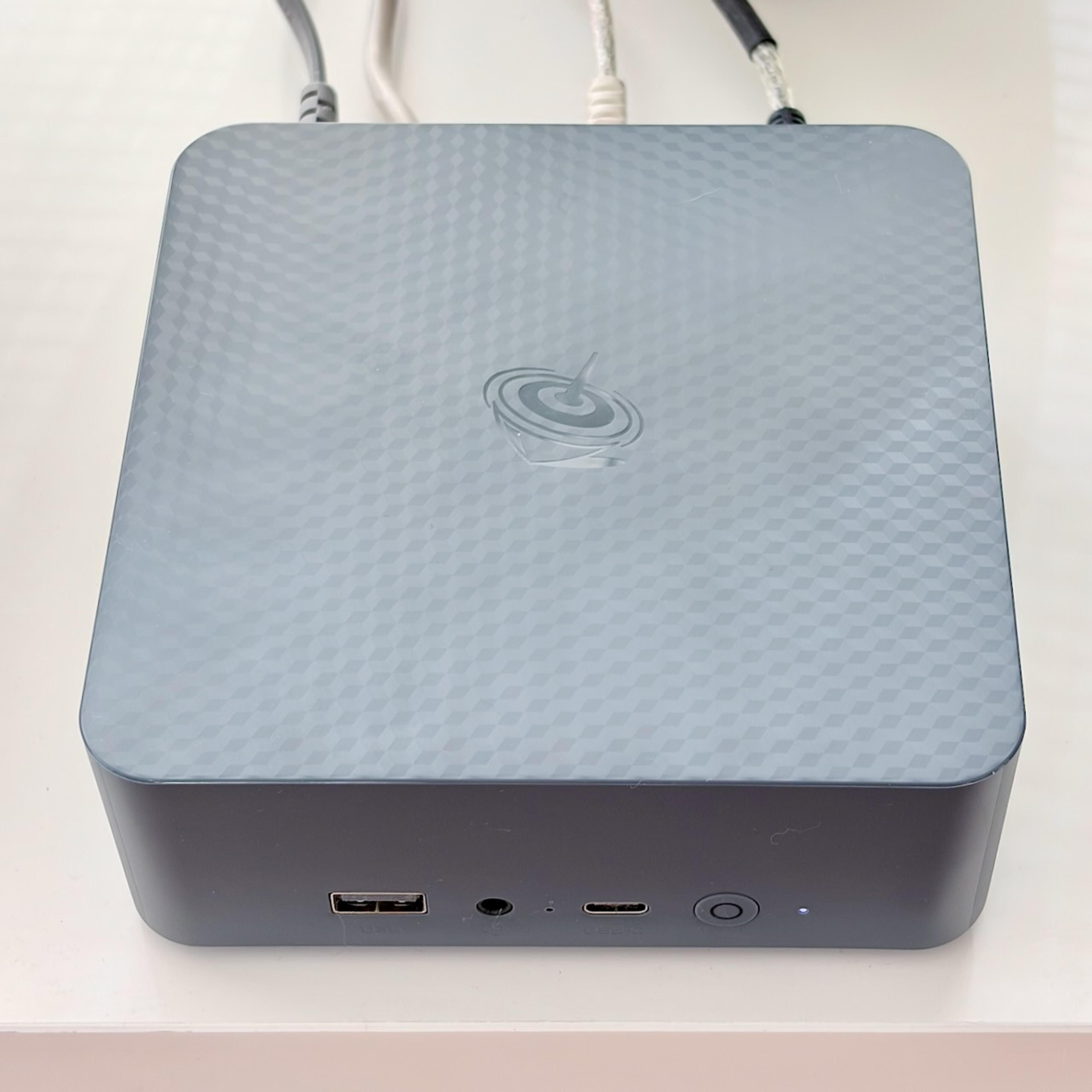 A photo of a mini PC media server on a shelf