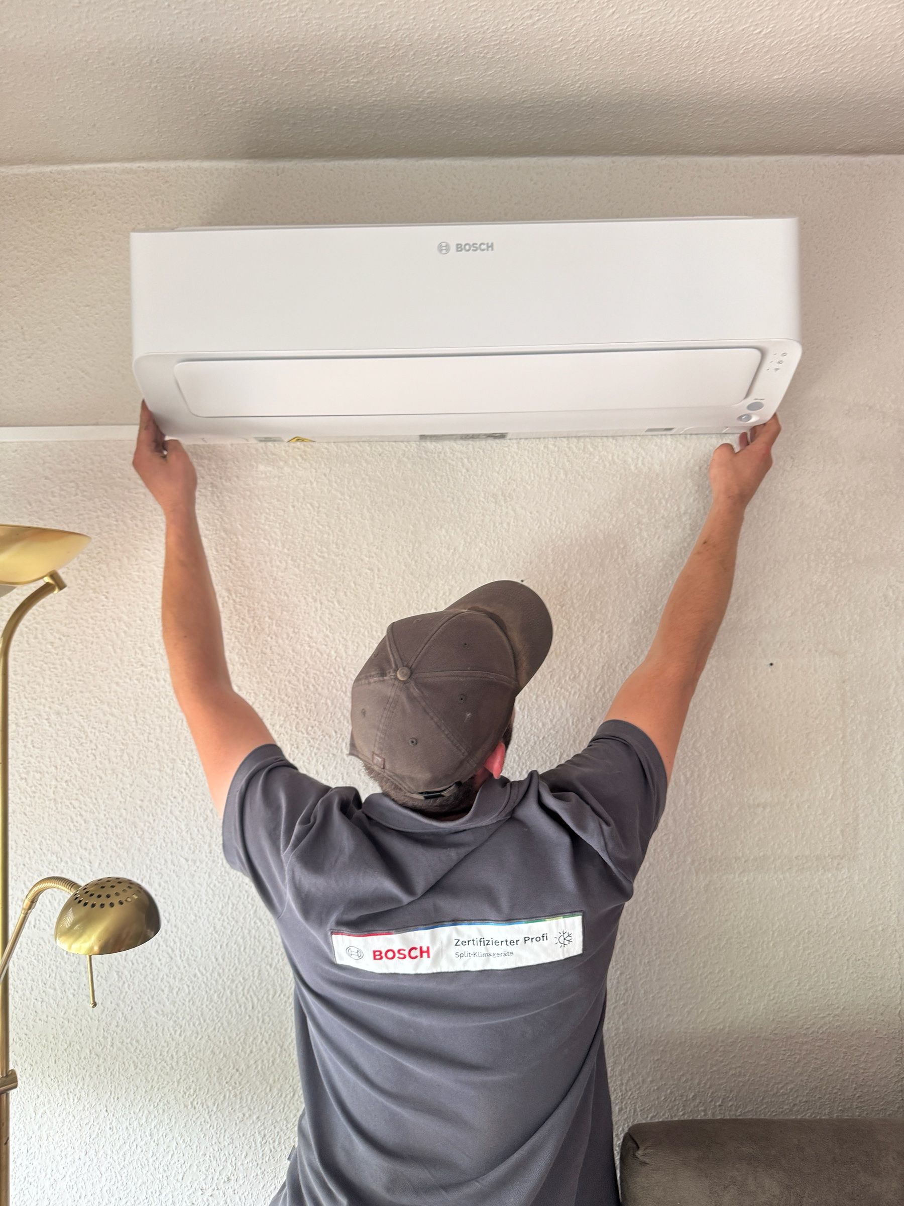 Monteur bei der Montage eines Bosch-Innengeräts einer Klimaanlage an der Wand