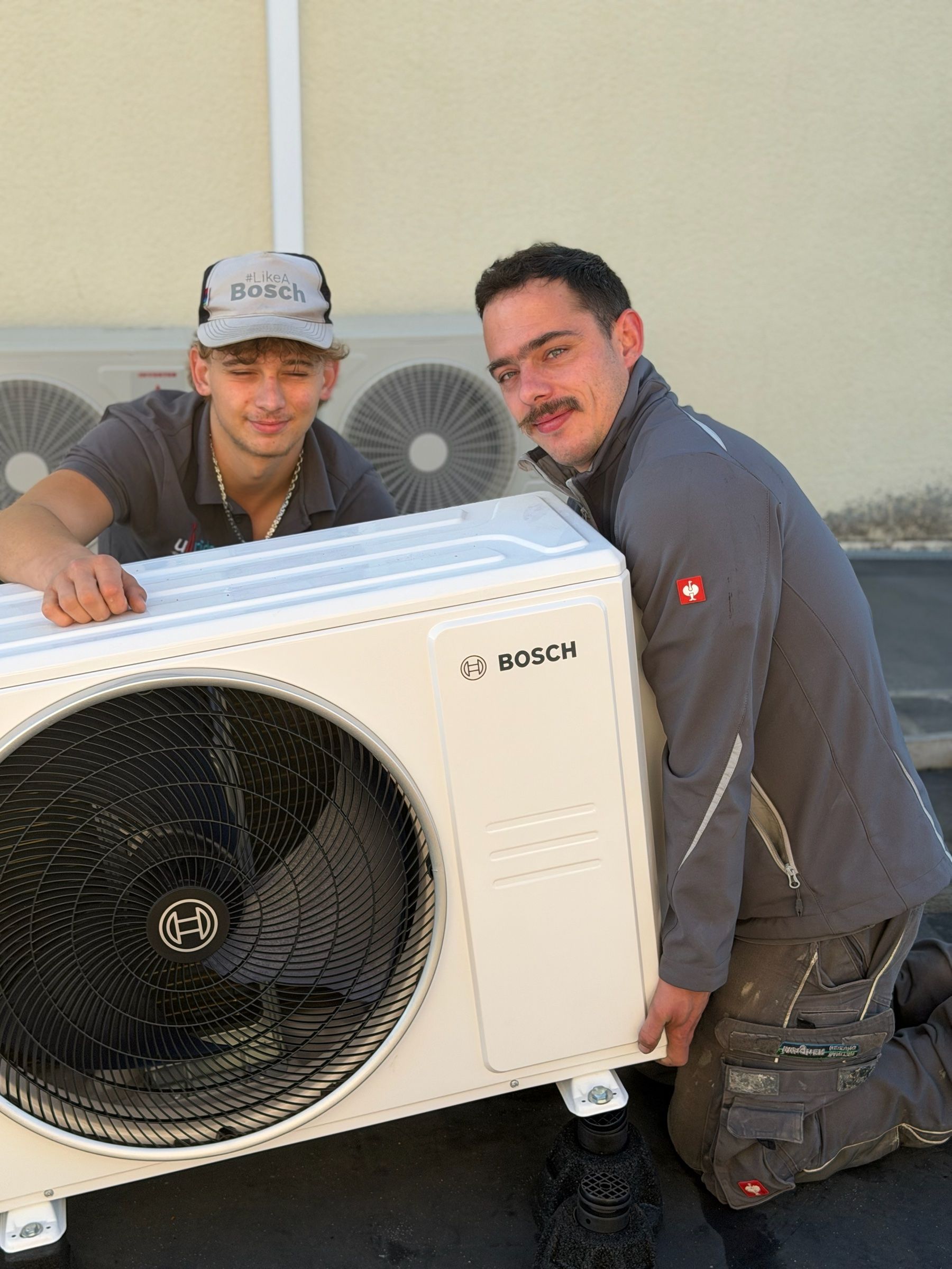 Zwei Monteure bei der Montage eines Bosch-Außengeräts einer Klimaanlage