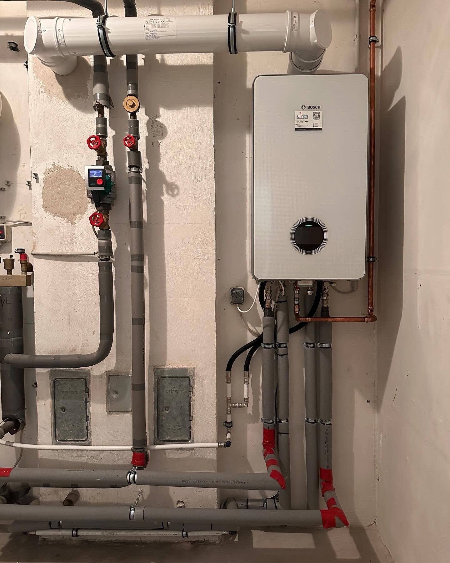 Wandhängendes Bosch-Gas-Brennwertgerät mit Rohrleitungen in einem Technikraum