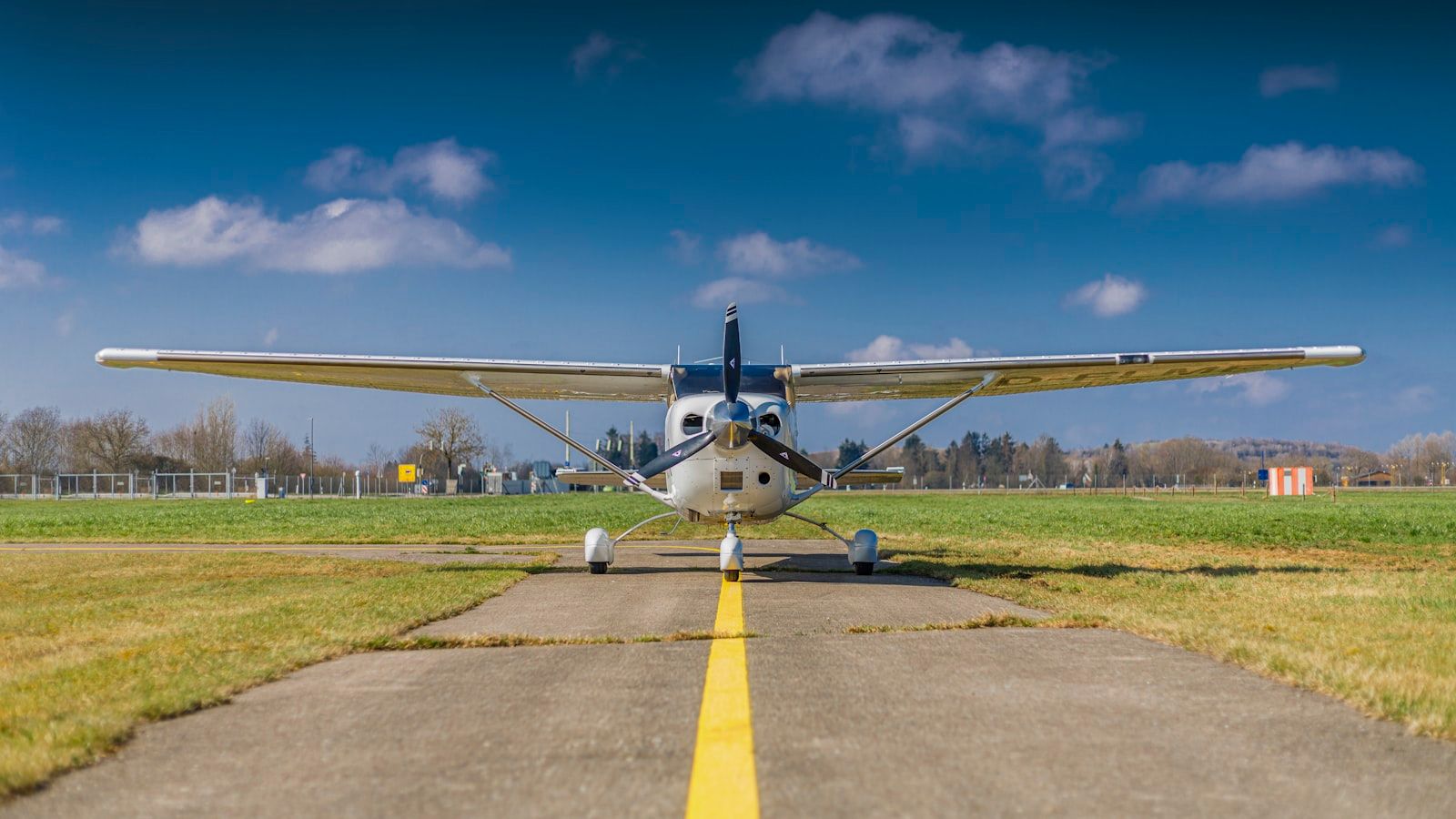 Petit avion stationné sur une piste sous un ciel bleu — illustration du projet PV + BESS de l'Aéroclub Arc