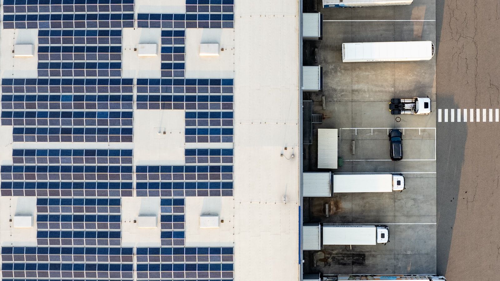 Aerial view of an industrial building equipped with a large photovoltaic rooftop installation
