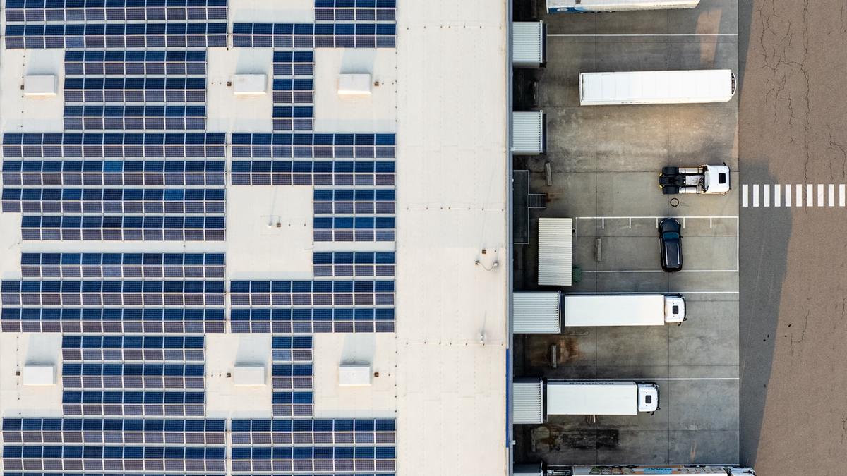 Vue aérienne d'un bâtiment industriel équipé d'une large installation photovoltaïque en toiture