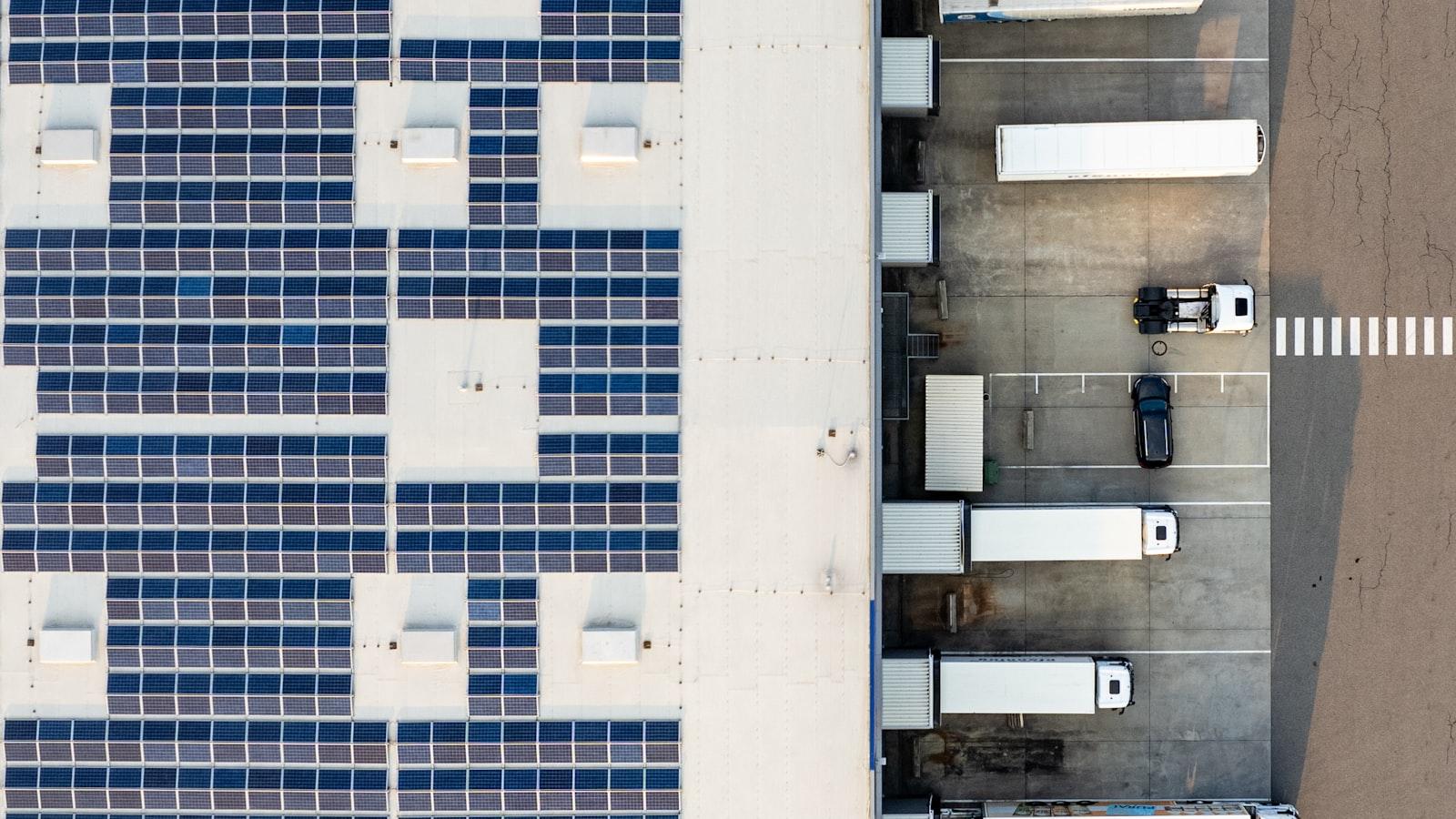 Aerial view of an industrial building equipped with a large photovoltaic rooftop installation