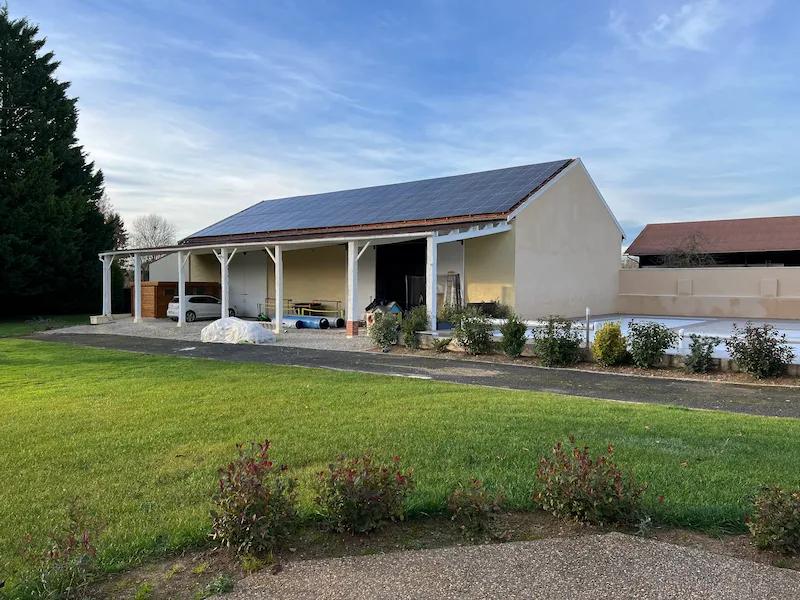 Exterior view of the L'Artbanne gîte with rooftop solar installation in the Champagne countryside