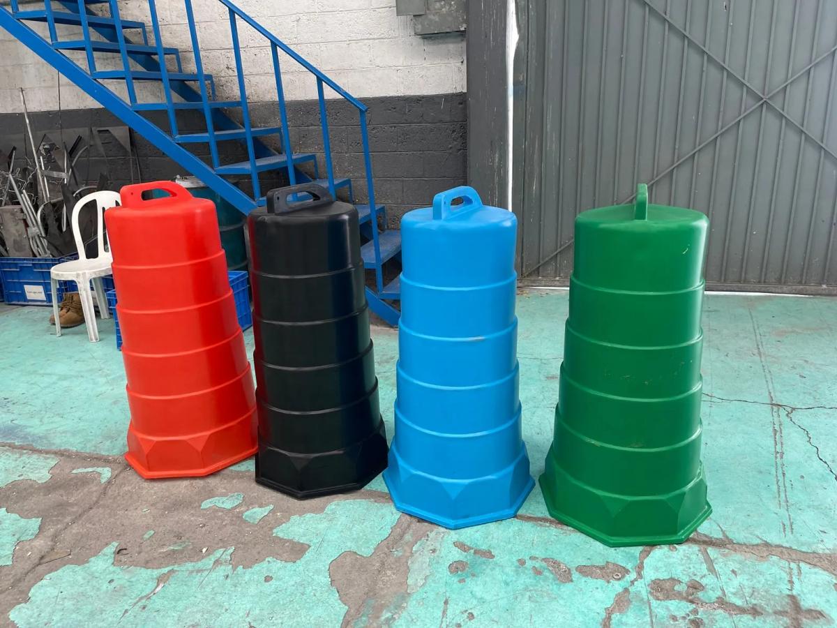 Cuatro trafitambos sin reflejante en rojo, negro, azul y verde dentro de una nave con escalera azul