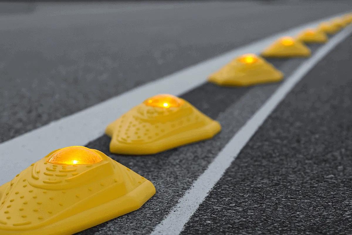 Fila de canalizadores kayak amarillos con luz ámbar encendida sobre la línea blanca de un carril