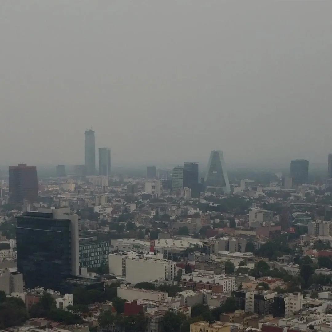 Vista aérea de la Ciudad de México cubierta de esmog, con rascacielos al fondo