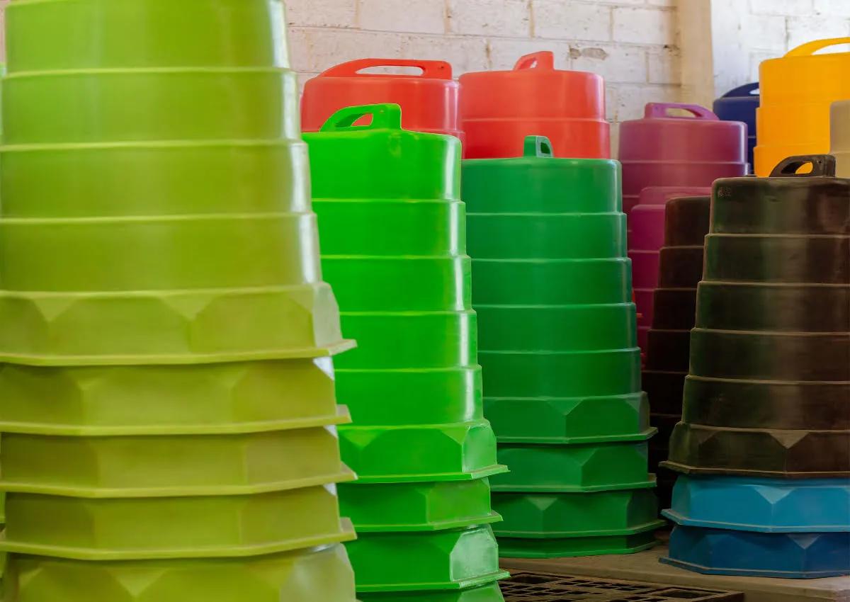 Pilas de trafitambos verde limón, verdes, rojos, rosas, amarillos, negros y azules dentro de una bodega
